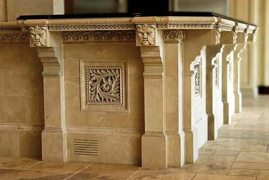 This stone bar features Absolute black granite, light walnut travertine and Texas Creme with Ellison masks, scrolled leaf inserts, shell, scroll, and ribbon and bead borders.