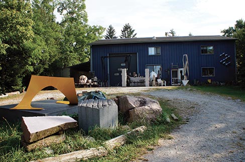 Jon Barlow Hudson’s studio in Yellow Springs, Ohio is 36 x 60 feet and two stories high, and has a seventeen-foot high shop space with a third of it being office and gallery space in the upstairs. It sits on 1.4 acres on the edge of town. Jon says that with the help of his Dad, “It was great fun to build! That was in 1984.”