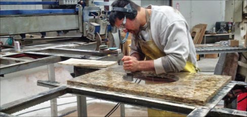 Matthew touches up a bowl hole in the Prestige Granite shop.