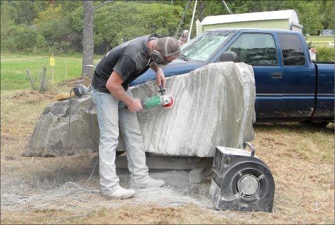 Artist Lance Carlezon trying to keep cool, and keep the dust downwind of him and his work. 