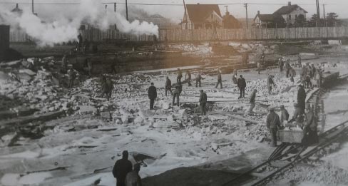 Archive photos show the first quarry used in the construction of the Illinois State Penitentiary. The prison was built on top of the quarry using inmates for laborers. The Quarry was run by Lorenzo B. Sanger and Samuel K. Casey. Prison architects were from Chicago, W.W. Boyington \and Otis L. Wheelock, who also designed the landmark Chicago Water Tower and the State Capitol. A quarry across the street (at right) was also opened, enabling them to quarry enough stone to finish the immense prison construction project. 