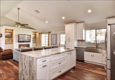 The clean lines of this mitered and laminated granite island makes it the center-piece of this open-plan combination kitchen and family room in a custom private residence.