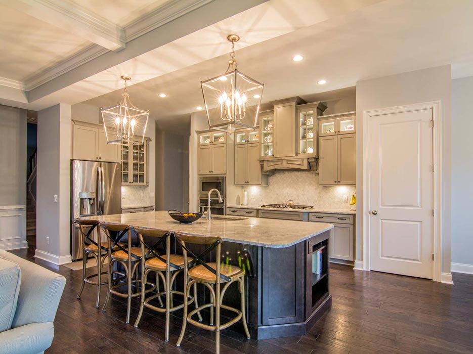 Custom cabinets frame a traditional cooking alcove, fronted by an oversize prep island and entertaining space – typical Granite Empire quality.