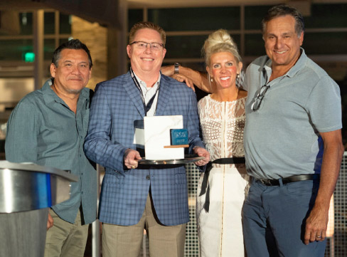 The 2019 Envision Award presented to WilsonArt, by ISFA President Augie Chavez (left) and ISFA Executive Director Amy Miller (second from right). 