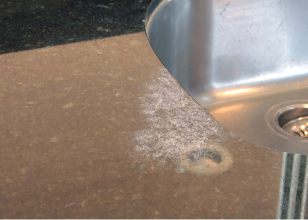 Toilet bowl cleaner damage on Ubatuba. The polished shine may be unchanged in the damaged area, but grinding is the only way to remove acid damage. 