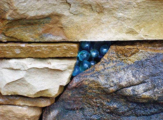 A trademark Hammerhead marble pocket in a Crab Orchard limestone and mixed stone wall.