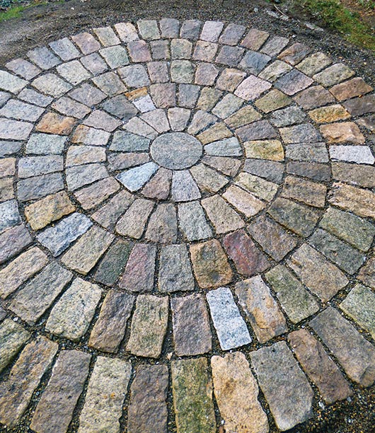 Archambault used a hand tracer chisel to split the stones in this circular cobblestone patio, which features at least three distinct types of granite gathered by the homeowner over the last 30 years.