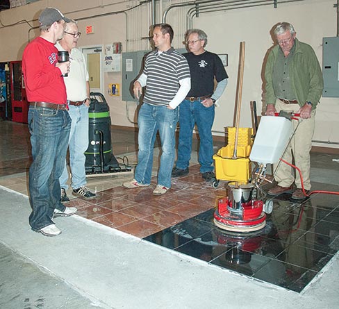 Polishing stone flooring requires different abrasives or chemicals for the different chemical and physical characteristics of each kind of stone. Above, Bob Murrell (second from left) teaches the different techniques for marble and black granite restoration at a recent hands-on workshop at Braxton-Bragg.