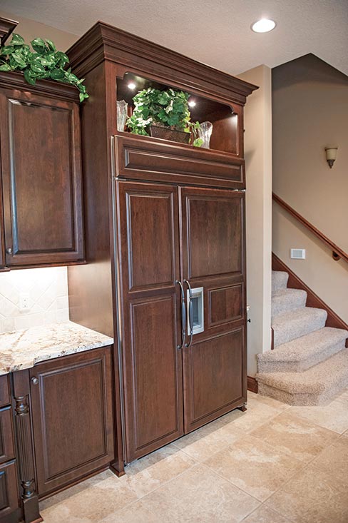 Netuno Bordeaux 3cm granite combined with Kemp custom cabinets provides both classical charm and function to this upscale kitchen setting. Kemp Cabinets, LLC is a medium sized Amish custom cabinet manufacturer located in Indiana.