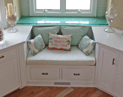 In order to help provide some cushion against direct contact with the quartz surface, Cole brothers researched and found a clear plastic mesh that they were able to put under the glass top in this kitchen nook.