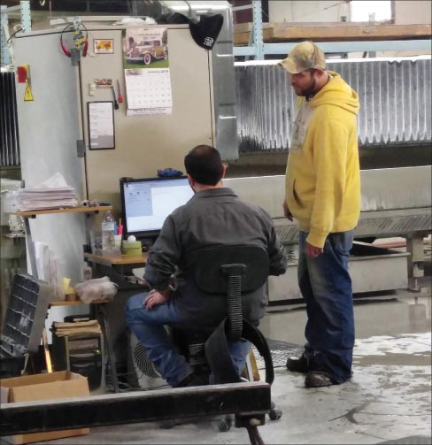 Emco-Williams employees Jon Burns (seated) and Chris Maples check settings on one of the company’s two Bavelloni CNC machines.  “Our CNC machines are the backbone of our production,” said Grove.