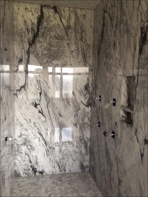 Grey Pearl marble shower, cladding sourced from Polycor, with matching octagonal mosaic floor.