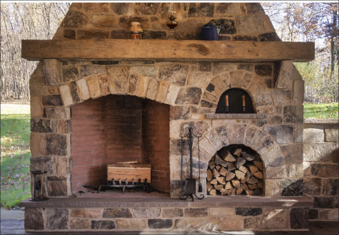 Outdoor Kitchen and entertainment area with an over-size fireplace also showcases their ashlar fieldstone construction.