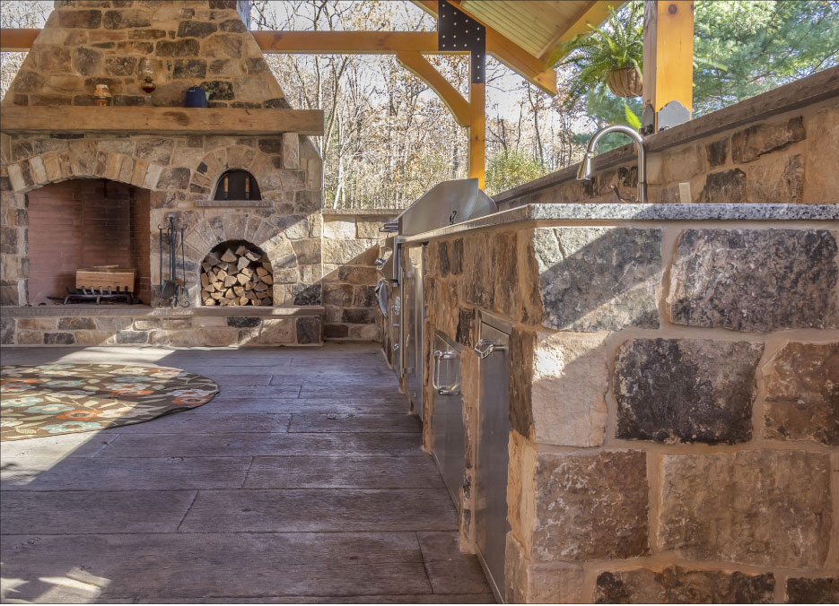 Outdoor Kitchen and entertainment area with an over-size fireplace also showcases their ashlar fieldstone construction.