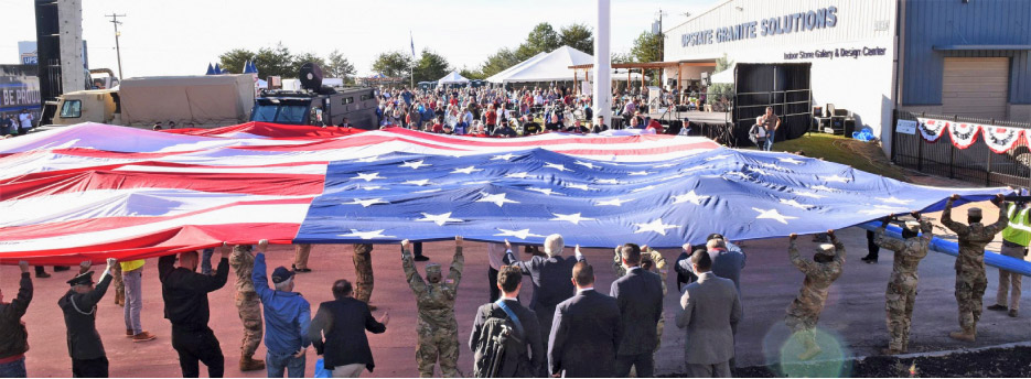 U.S. Armed Forces veterans and volunteers unfurl the giant flag in the Veteran’s Day program at Upstate Granite.