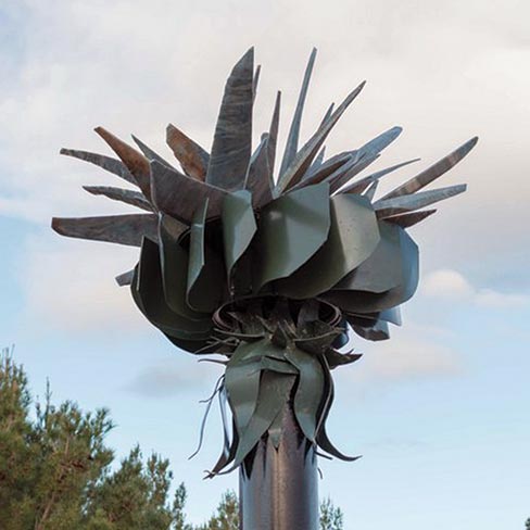 “Wind Flower,” another delicate beauty carved from Brazilian Blue quartzite is 14 feet high, 30 inches wide and 30 inches deep. Using elements of Aluminum and Steel, Eino’s interest in wind-powered sculptures was renewed in 2011. A major challenge was balancing the upper portion so that a 5 mph wind will turn the sculpture. The highest speed to date is 40 revolutions per minute.