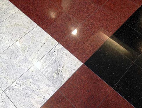 Lobby floor using polished granites and marble. Be aware that combining marble with granite may build in maintenance problems as the two materials are restored with different abrasives, even though the maintenance procedures may be similar.