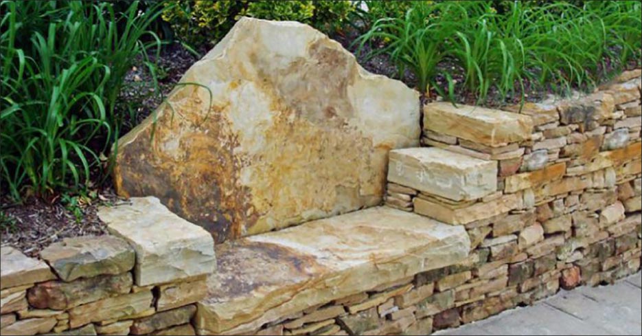 A combination retaining wall and bench made from stone remnants.