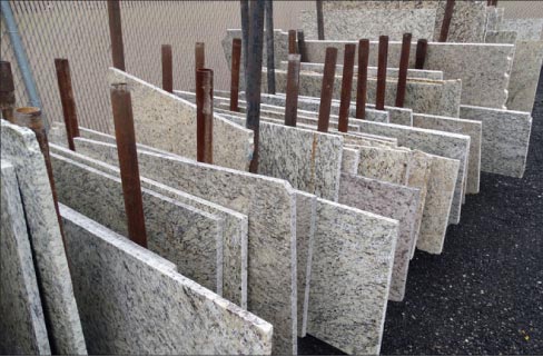 Granite remnants at a stone yard safely stored and reserved for selection and fabrication.