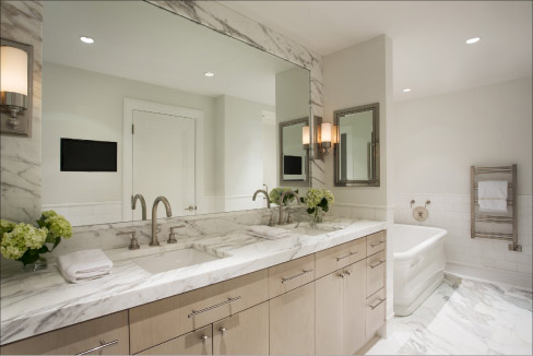 Mitered Calacatta master vanity countertop with matching backsplash and mirror frame designed by Lewis Interiors and built by Adams & Beasley Associates.