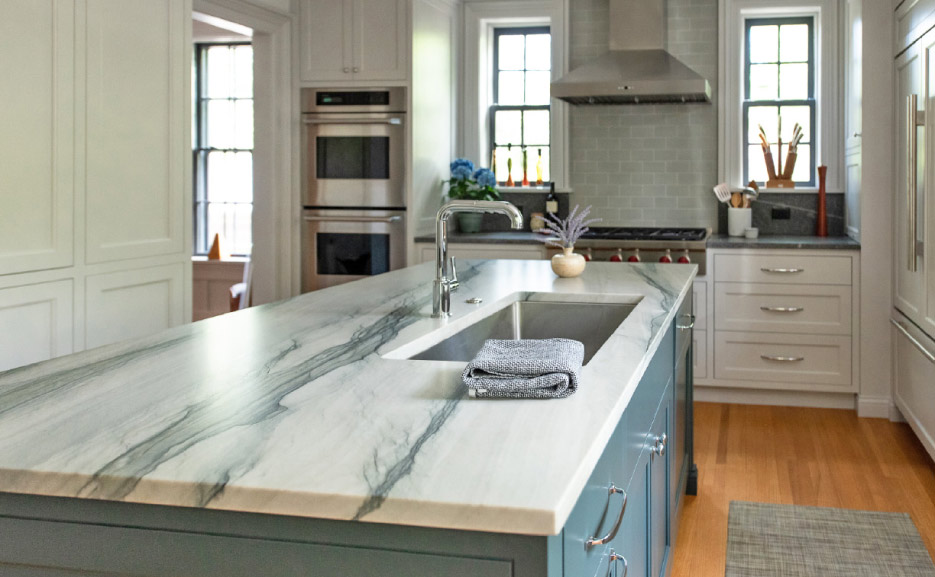 In this client’s kitchen, Shumaker paired a Brazilian Calacatta quartzite with blue cabinetry. Photo courtesy Shumaker Design & Build Associates