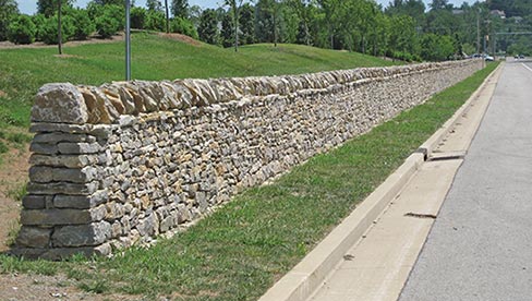 The Hillsboro Road reconstruction project in Tennessee involved rebuilding more than 1,000 linear feet of historic stone wall that was destroyed a few years ago when the roadway was widened. The original stone was salvaged by local preservation-minded people and stored at a county facility while funding was secured for it to be rebuilt. All the historic stone was used in the new wall . . . along with some new stone for structural improvements (foundations, ties and covers) that were missing from the original wall design. Williamson County is the project sponsor, with 80% of the funding provided by the Tennessee Department of Transportation