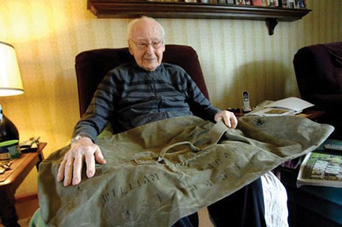 World War II veteran William Kadar holds his old Army duffel bag that bears his name at his home in Merrillville, Indiana. The 92-year-old Kadar says he last saw the bag in November 1944, a month before he was captured by the Germans. His granddaughter says a 16-year-old French boy found the bag in his grandfather’s house and tracked Kadar down. Photo: Post-Tribune, Stephanie Dowell / AP