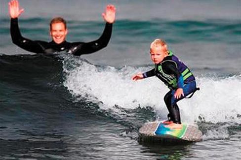 Triston Gailey, 3, surfs a wave as his father, Todd, watches in Morro Bay, Calif. on Thursday, Aug. 29, 2013.  Photo: The Tribune (of San Luis Obispo)