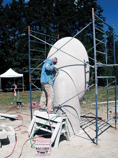 The 2011 Schoodic International Sculpture Symposium in Prospect Harbor, Maine, by all standards, was a smashing success. Here Hoshi is putting on the final bush hammer finish on her sculpture titled “Warm Wind.” Final placement of this large project sits proudly in Roque Bluffs, Maine.