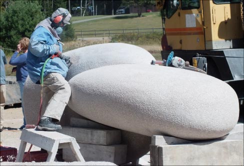 The 2011 Schoodic International Sculpture Symposium in Prospect Harbor, Maine, by all standards, was a smashing success. Here Hoshi is putting on the final bush hammer finish on her sculpture titled “Warm Wind.” Final placement of this large project sits proudly in Roque Bluffs, Maine.