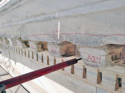 An area of cornice and overhang shows the typical sugary deterioration from water run-off and weathering. Sections are numbered and cataloged for replacement.