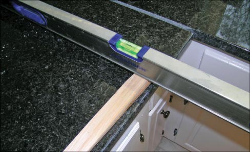 Installers know that countertops need to be level, and more the uneven the cabinets are, the more you need to shim. This can creates a gap between the cabinets and the countertops. If the gap is small you can caulk it, but if the gap is large and caulk won’t cover it, then wood trim needs to be installed, which is usually the customer’s responsibility.  But what usually happens is that the contractor or the customer calls and either says there is a gap or they can see the shims, making it YOUR problem.