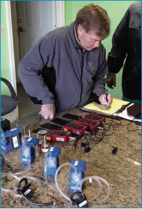 Richardson calibrating noise dosimeters and air pumps prior to shop environment testing. 