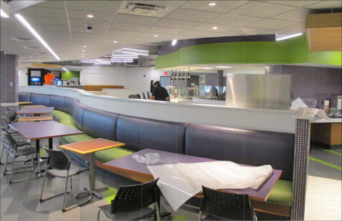 A recent Niagara University project (shown in progress) included a refit of solid surfaces throughout Clet Hall. Above and below: cafeteria installation of a long, curved bench barrier separating seating and the serving line, and the tray return area.