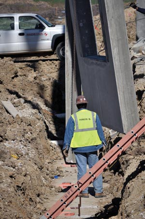 Tilt-up concrete panels are set on permanent, high-strength, rectangular, plastic shims. The shims create an open joint between the panel and the grade beam to receive grout, backer rod, and sealant.  Image courtesy Tilt-Up Concrete Association