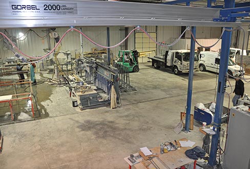 Craig and Jackson on the far left are discussing the day’s goals, while Tony removes an A-frame from the truck. Owner, Jon Rathke can be seen at far right, on his way through the shop to touch base with his crew. The organized and well-fitted shop consists of a Z. Bavelloni Sharp 500 bridge saw; two Thibaut radial arm machines used primarily for sink cutouts, honing and texturing; and two hand-guided edge routers for profile work. Two Gorbel overhead bridge cranes and Woods and Manzelli vacuum lifters help stone safely move through the shop, and a Water Treatment Technologies recycling system takes care of the slurry.