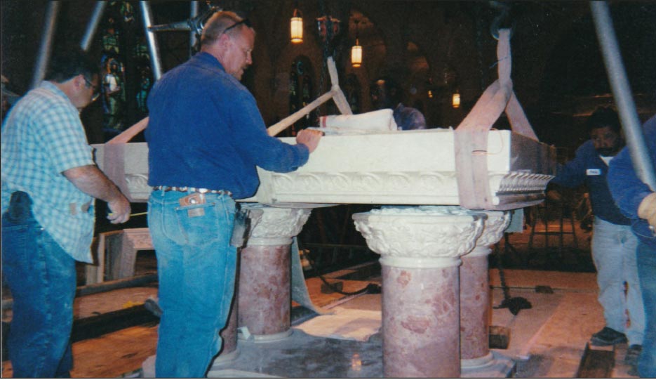 Step 10: All are breathing a little sigh of relief as the piece is now above the support columns. Everyone is busy centering the piece onto the column base.