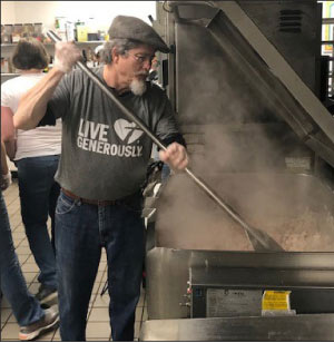 The team from Braxton-Bragg prepares fresh ingredients to feed the homeless at KARM.