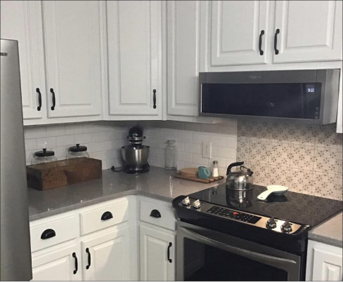 This Farmhouse kitchen by Premier Countertops mixes traditional with the modern in this cozy setting.  Durable LG Viatera Lento countertops and a modest size island keep the kitchen space from being cramped, and provide an ample workspace and dining area. The pattern tile backsplash and contemporary subway tiles work to create a clean look with a warm spot of color interest. Says Wadell, “We have a lot of customers who ask about tile for their backsplashes and floors, so we decided to move into that portion of the business.”