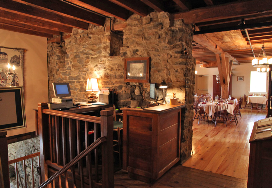 The Inn at Millrace Pond hostess station second floor, showing the support beams running throughout the Interior of the old grist mill. Just down the stairs is the grinding room where the water race entered the mill. 