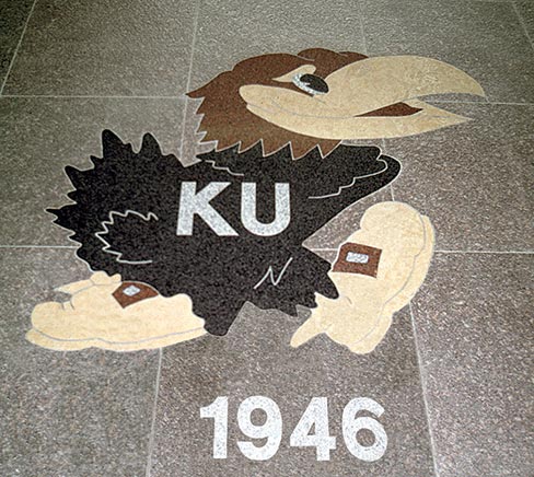 Custom logo art can be created in most hard surfaces to match the surrounding flooring, or in the case of middle and high school emblems, to meet a range of school budgets. The more colorful renditions can incorporate a variety of durable, hard materials including stone, tile, metal, glass, concrete or terrazzo.