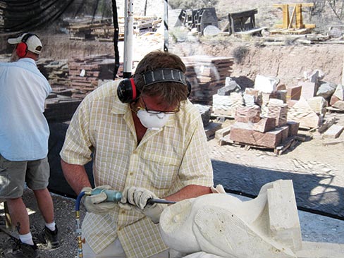 Student Antoine Leriche (New Mexico) uses an air-powered chisel to shape his owl.