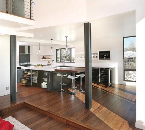 After: the kitchen and great room have been transformed into a bright, welcoming space, using 2cm Silestone White Zeus with a 3 inch mitered edge, mated with a 3 inch thick slab of solid walnut. This kitchen features all undercounter refrigerators.