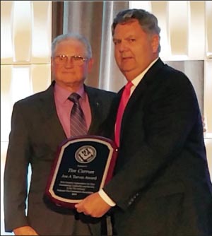 Joe Tarver, left, presents Tim Curran with the 2015 Joe A. Tarver Lifetime Achievement Award at the Coverings show in April.