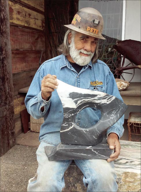 Pete shows off one of his free-form sculptures, carved from a scrap of the black marble from his stockpile. As with the Mayer quarry onyx, even small (unflawed) pieces can be valuable.