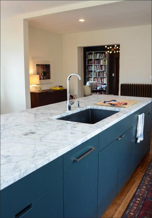 A hardware specialist installs custom fittings on these oversized doors. Note the protective drop cloth laid down to protect the new hardwood floors. Sharing construction space and cooperating with other contractors is a challenge when your area of concern is the floors, and either restoring them or preventing construction damage like stains and scratches.