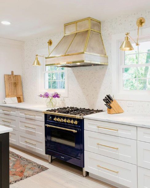 Brass accents add brightness and warmth to the range hood and carry throughout the kitchen in hardware, lighting and appliances.