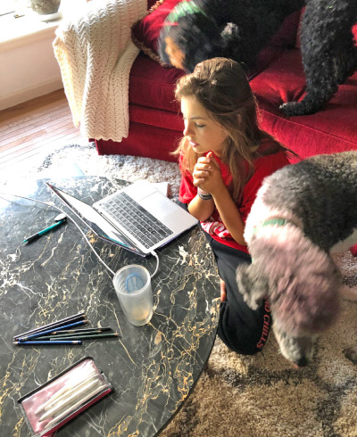 Taylor, my youngest daughter, doing her schoolwork via remote, with her current four-legged classroom peers, Buckley and Bailey supervising.