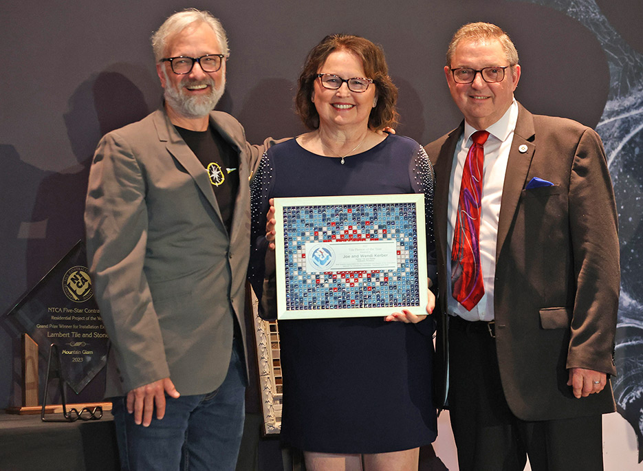 Dirk Sullivan presents Joe and Wendy Kerber with the 2023 Person of the Year  award at the NTCA Awards ceremony, Coverings 2023.