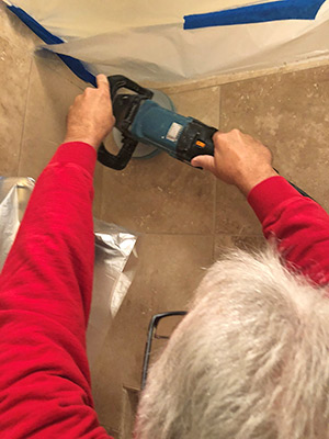 Using my Makita grinder to do tough work on a shower stall vertical surface. The “D” handle helps me maintain good control.